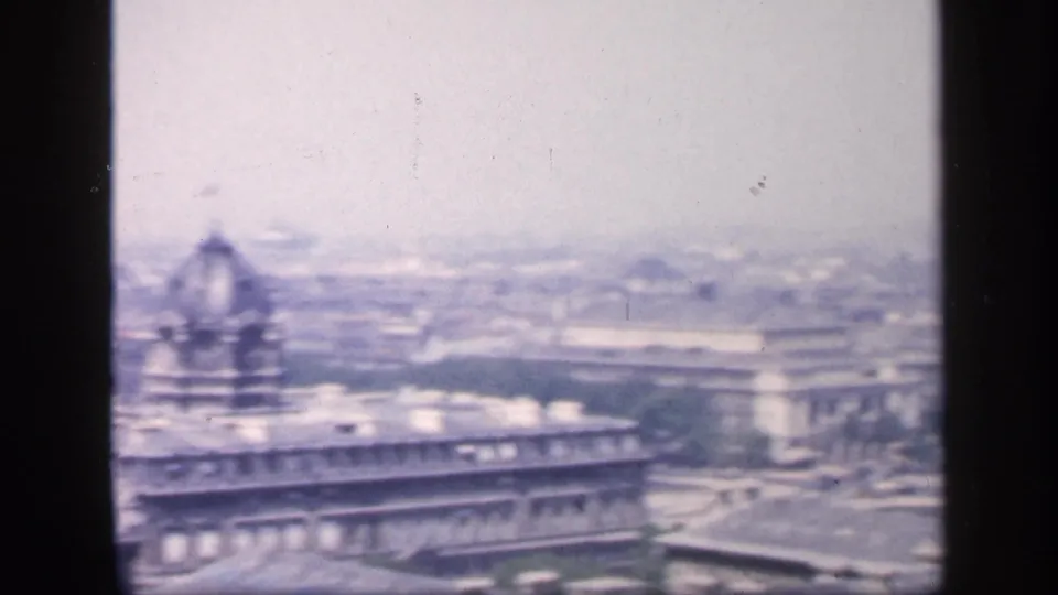 1949 New York City home-movie frame showing a soft, hazy skyline view with a domed building and dense rooftops.