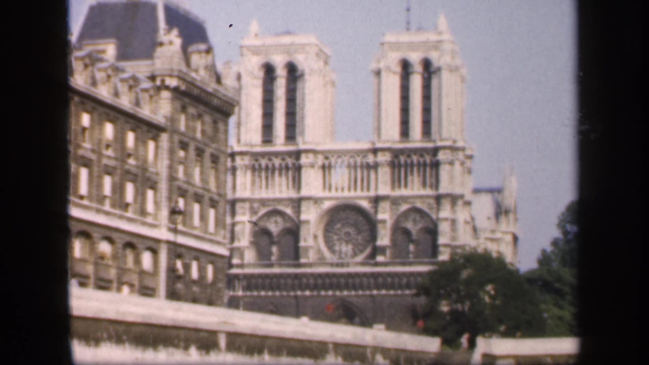 Notre-Dame facade with twin towers, rose window, and nearby buildings.