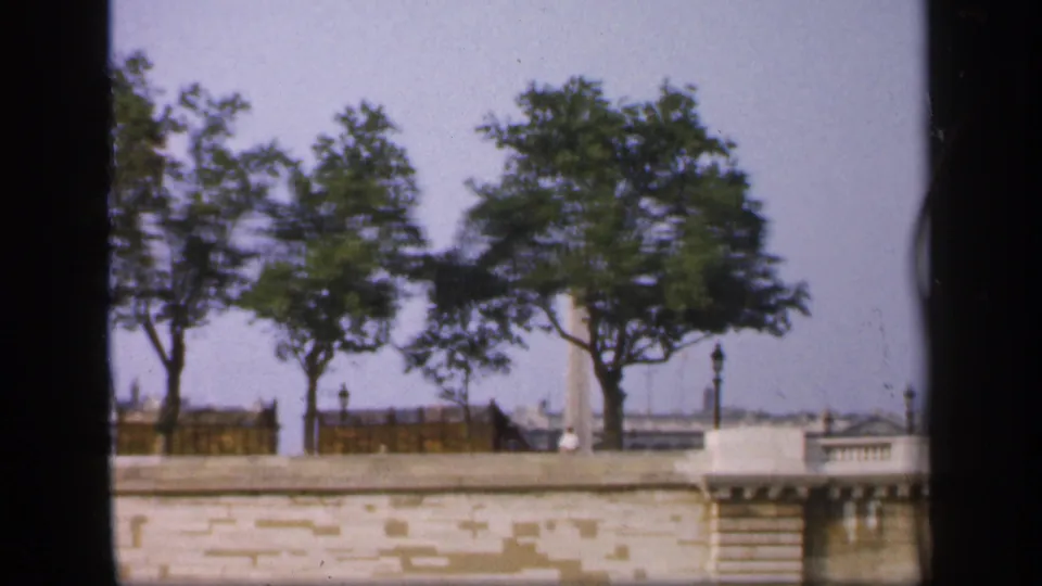 The 1949 French boat view shows leafy trees above a stone canal wall, with railings, lampposts, and distant buildings beyond.