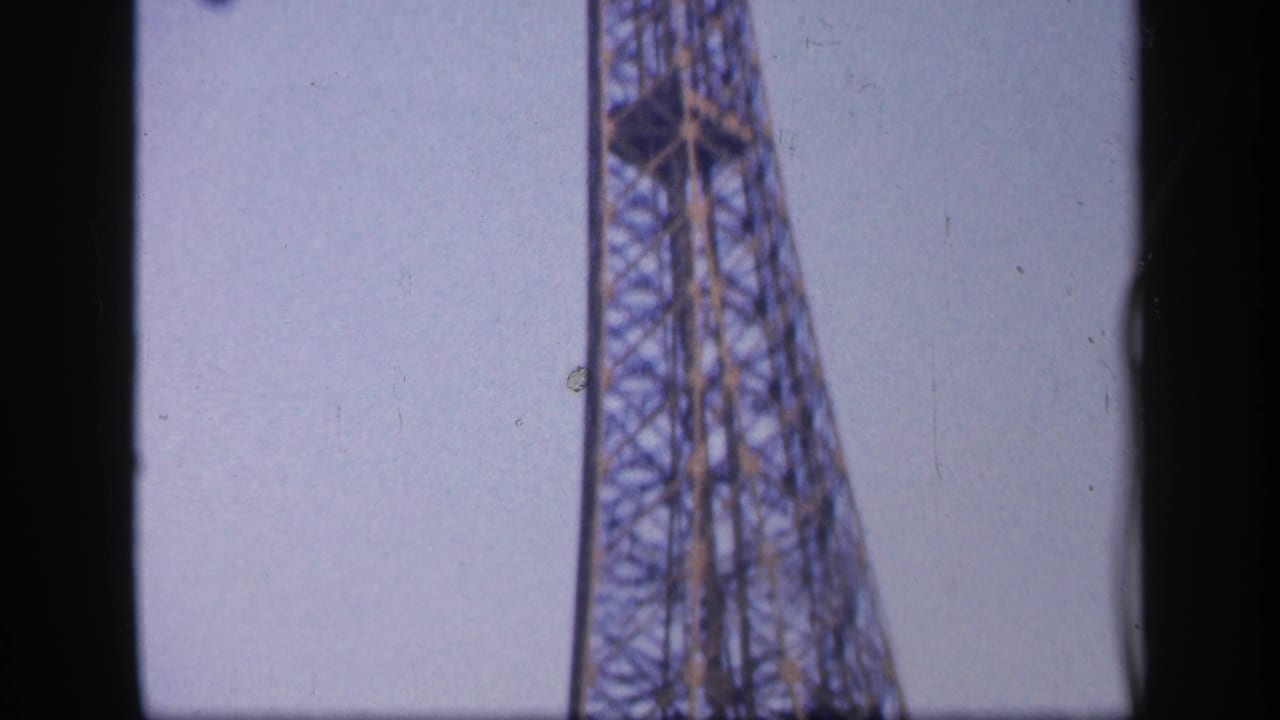 Narrow view of the Eiffel Tower rising against open sky.