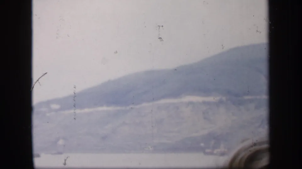 1949 Ireland 8mm frame showing a soft, misty hillside and water beyond dark window or viewfinder edges.