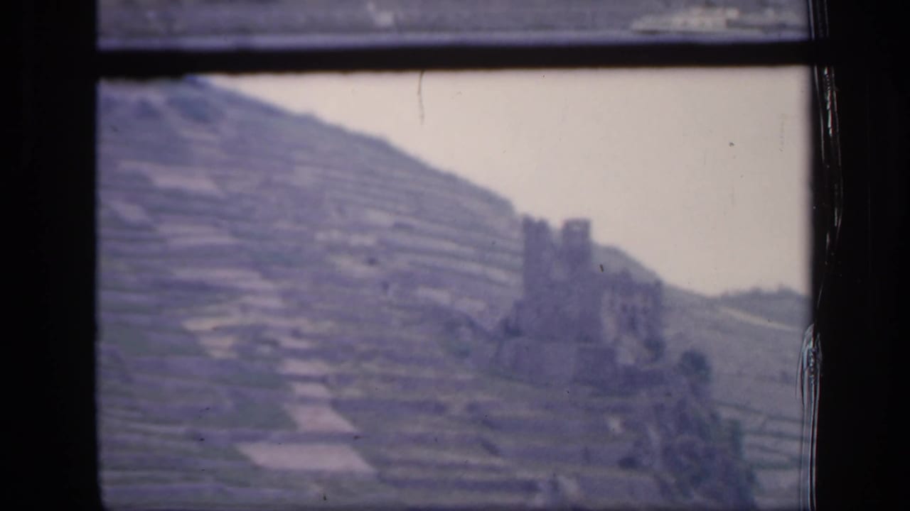 Hillside terraces with a weathered stone structure near the right side.