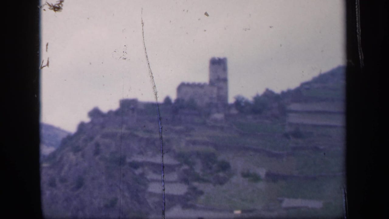 Distant hilltop castle above terraced slopes in a soft 8mm frame.
