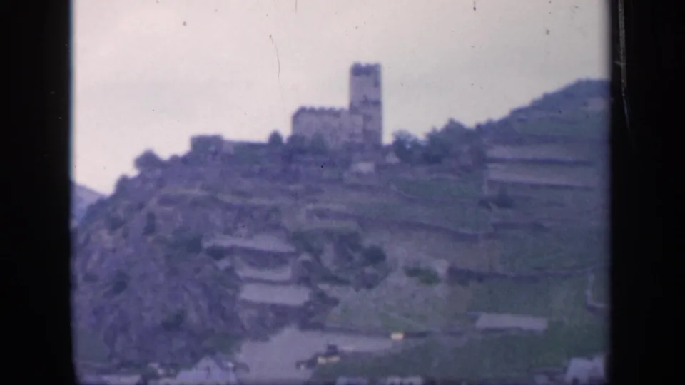 Distant 1949 Ireland view of a castle-like landmark on a hillside, framed by soft color and film wear.