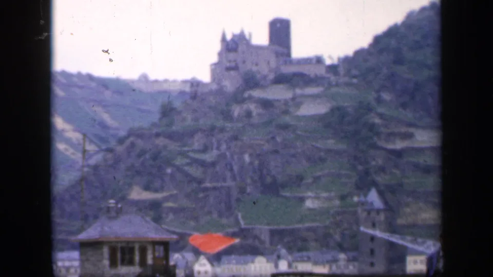 1949 Ireland home-movie frame showing a castle-like structure above terraced slopes and town buildings.