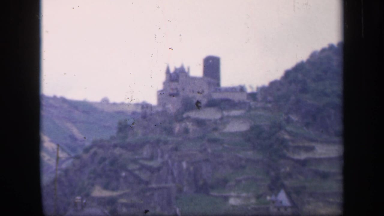 Soft 8mm view of a hilltop castle above terraced slopes.