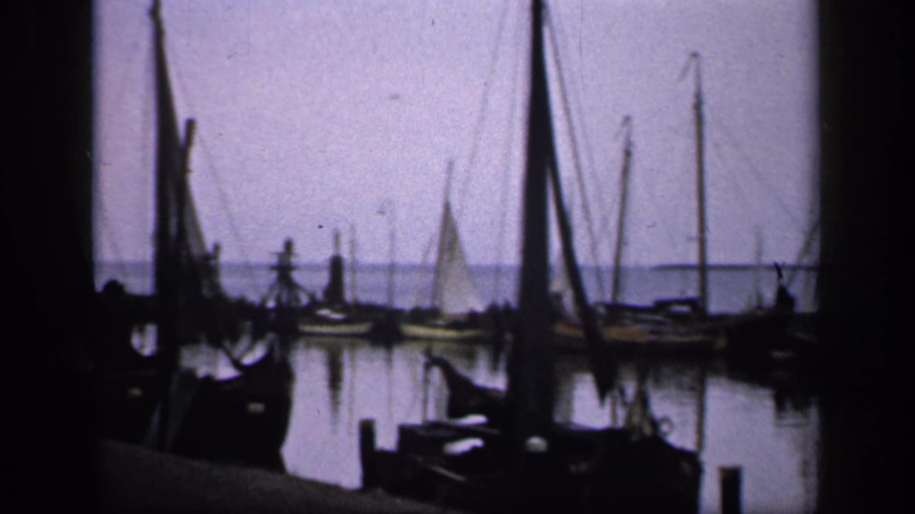 Harbor view with sailboat masts, dock posts, and calm water.