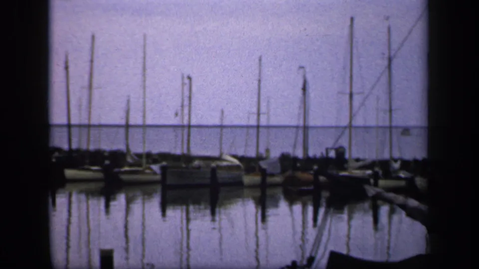 1949 Ireland marina view with multiple docked sailboats, vertical masts, and quiet reflections on the water.