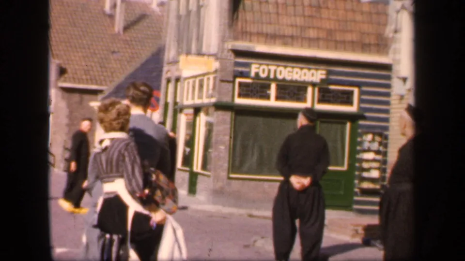 A late-1940s street view in the supplied Ireland setting, with pedestrians and a man near the FOTOGRAAF shopfront.