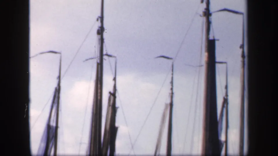 1949 Ireland 8mm still of furled sailcloth, multiple masts, rigging, and dock lamps seen from a steady harbor vantage point.
