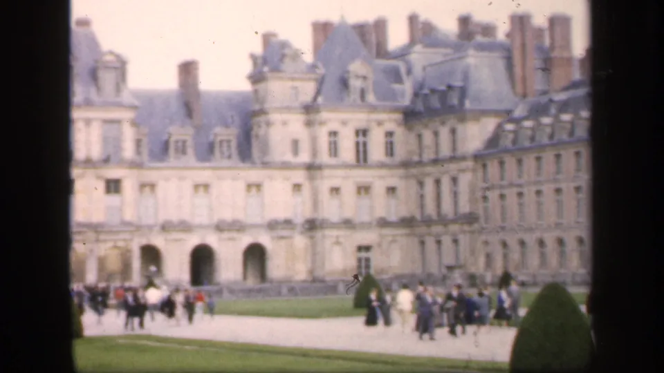 1949 8mm home-movie view of a castle-like historic building in Ireland, with visitors moving across formal grounds.