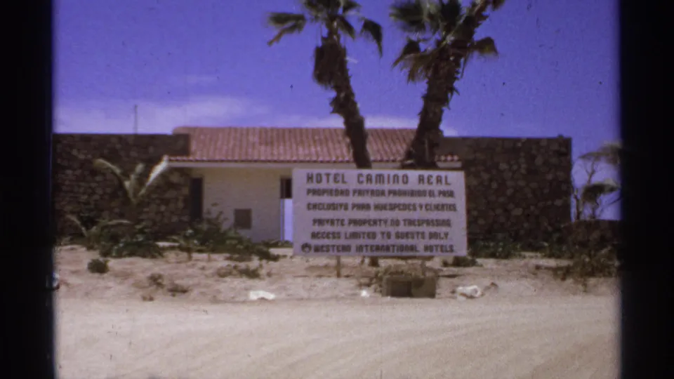 Hotel Camino Real sign appears outside a low resort building with palms in Cabo San Lucas, Mexico.