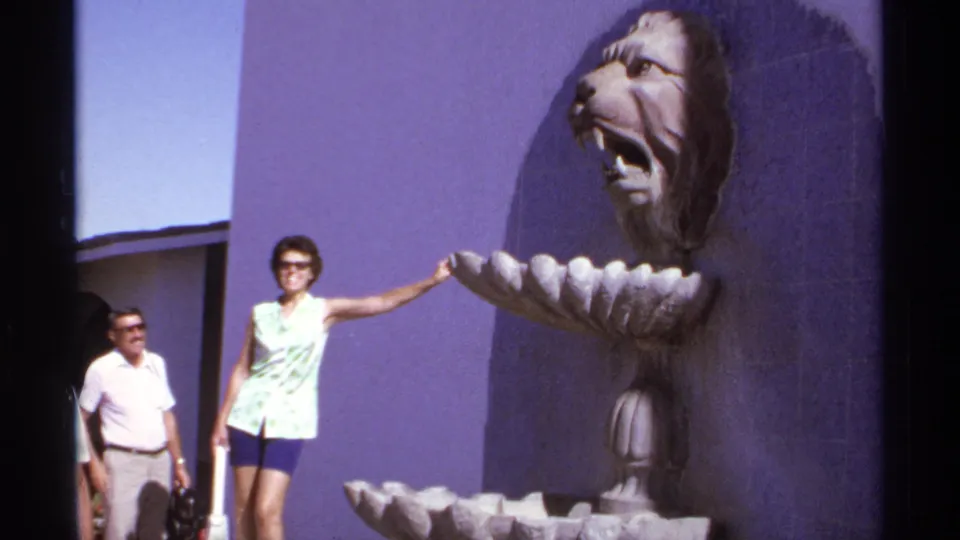 Cabo San Lucas 1974 8mm frame with adults posing near a sculpted lion-head fountain at a resort-like courtyard.