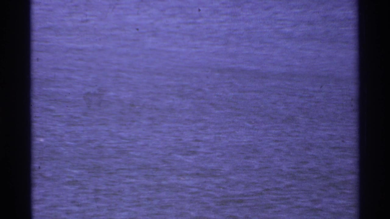 Rippled ocean water seen through dark vertical film borders.
