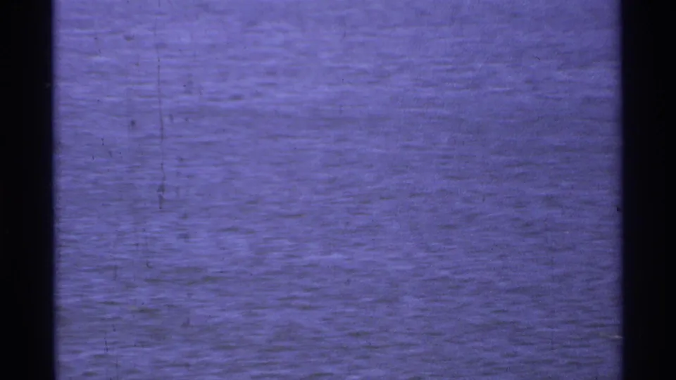 1974 8mm coastal water view from Cabo San Lucas, with soft focus, aged color, and visible surface ripples.