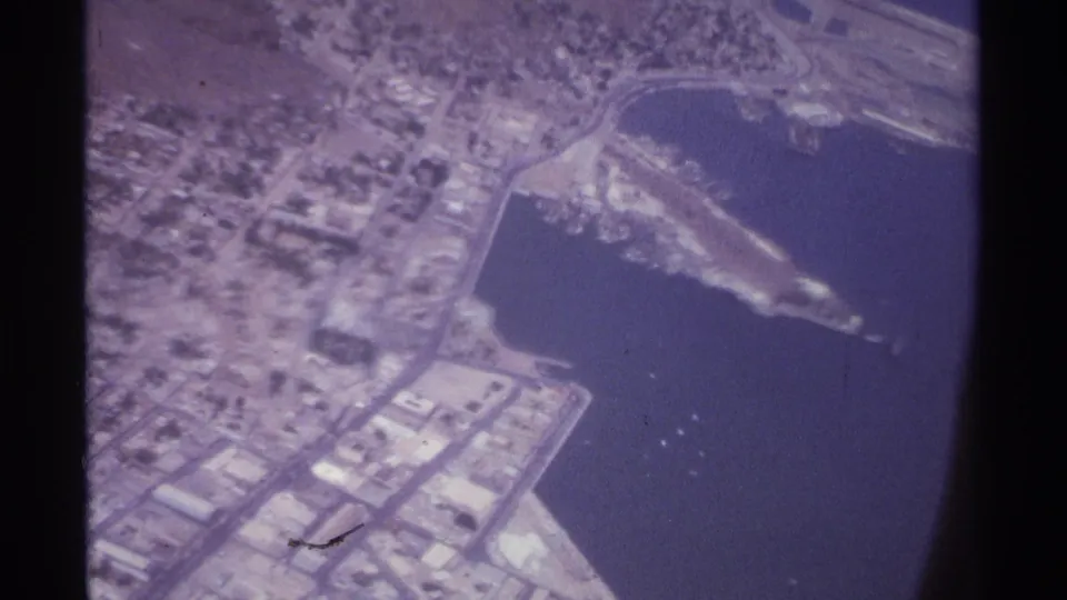 1974 aerial frame of La Paz, Mexico, with the bay, waterfront development, pier or breakwater, and dense low-rise street pattern visible.