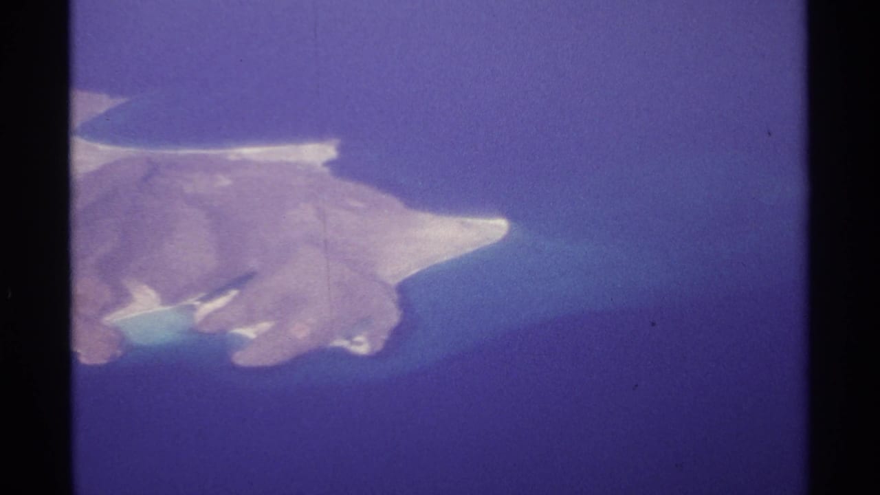 Aerial view of a rocky island with pale beaches surrounded by blue ocean.