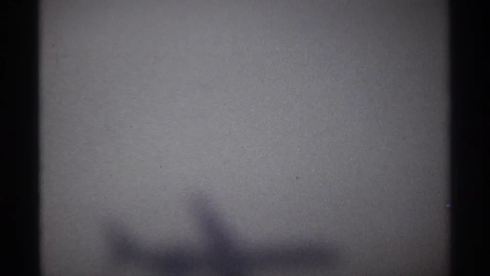 Final 1974 aerial frame from La Paz showing a soft, blurred aircraft shadow on a pale grainy field of view.
