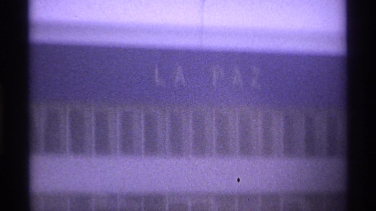 Large facade detail with faint LA PAZ lettering and dark vertical framing.