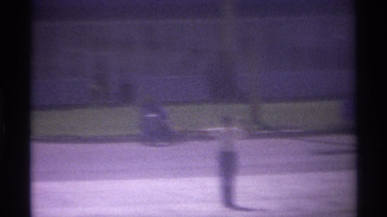 Blurred airport ground view with dark vertical shadows and indistinct equipment in the distance.