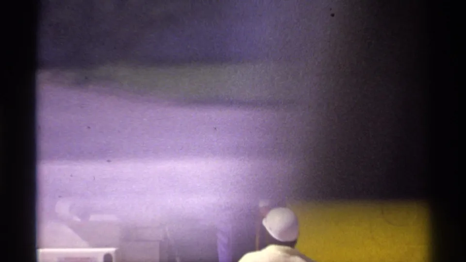 Partly obscured 1974 La Paz airport frame showing the yellow aircraft side, stairs, and a person barely visible near the lower edge.