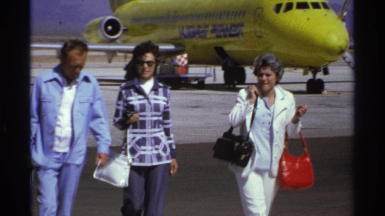 The 1974 La Paz tarmac view shows three adults with handbags walking past a yellow Kuwait Airways aircraft.