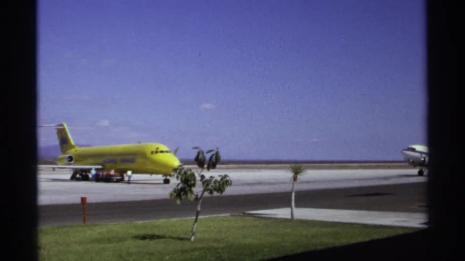 1974 La Paz airport view with a yellow parked jet and part of another aircraft entering at the right edge of the frame.