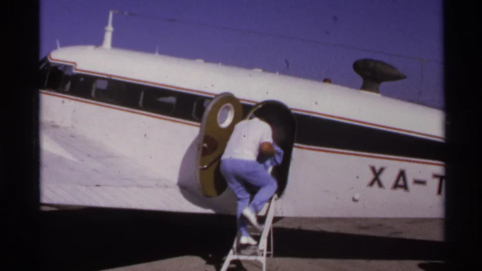 A man in light clothing climbs into a small commuter plane on the La Paz tarmac in 1974.