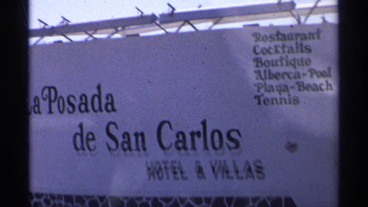 1975 Guaymas 8mm frame showing the La Posada de San Carlos Hotel and Villas sign with bilingual amenities listed.
