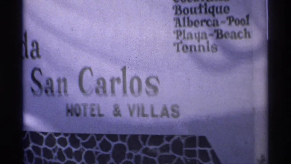 Close 8mm view of the La Posada de San Carlos Hotel and Villas sign in Guaymas, with the amenities list visible at upper right.