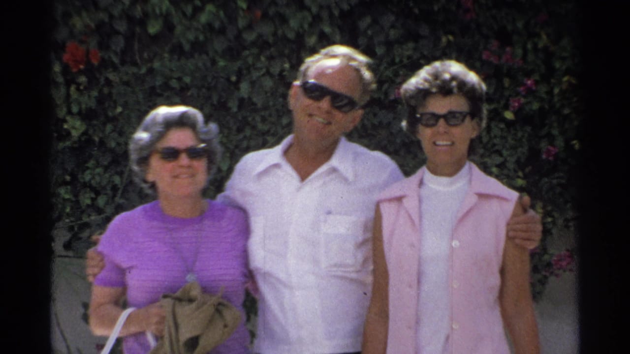 Three adults in sunglasses pose closely in the Guaymas 1975 footage, with saturated 8mm color and garden foliage behind them.