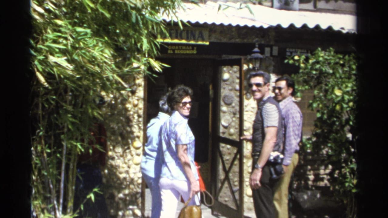 Several adults pause near an open entrance, with two men looking back toward the camera.