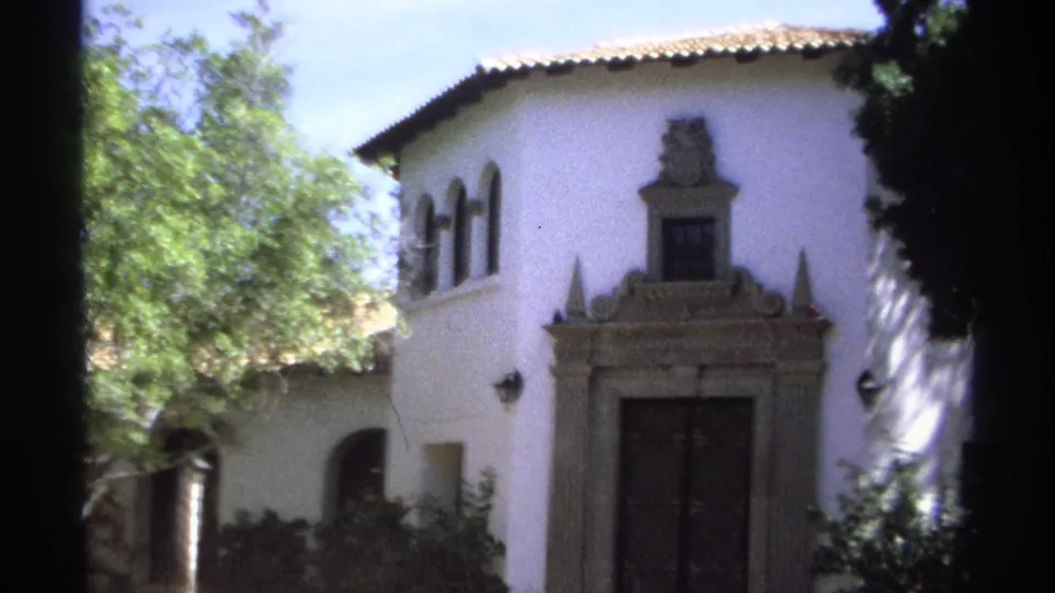 1975 Guaymas frame centering the ornate doorway and arched windows of a white stucco courtyard building.