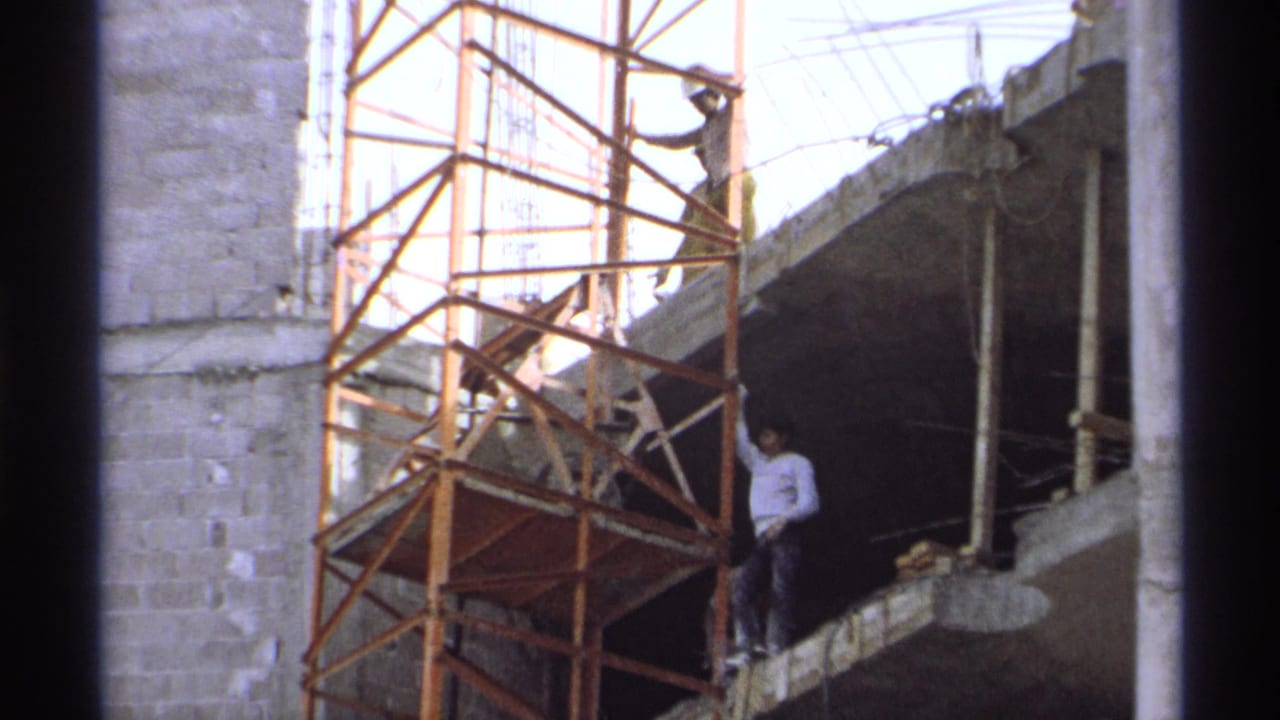 1975 Guaymas, Mexico footage showing workers on scaffolding beside unfinished concrete block walls and exposed rebar.