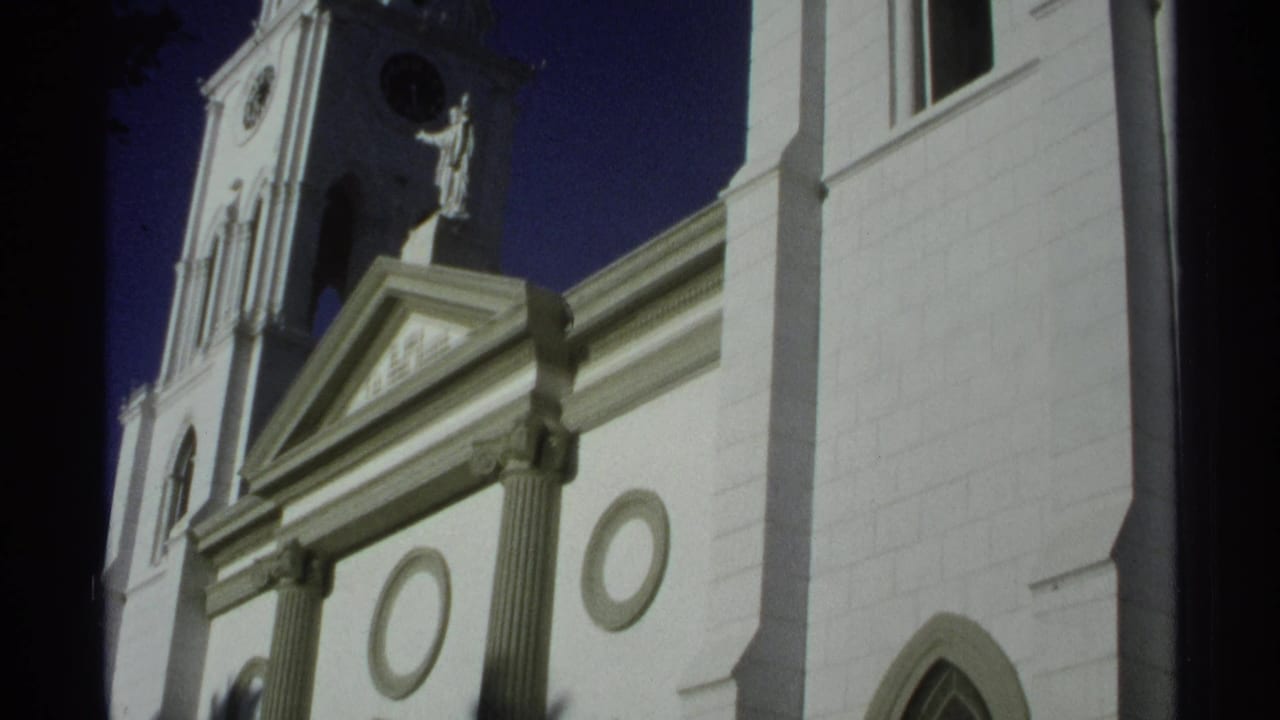 Final 1975 Guaymas frame showing the cathedral tower, statue niche, pediment and arched window in saturated 8mm color.