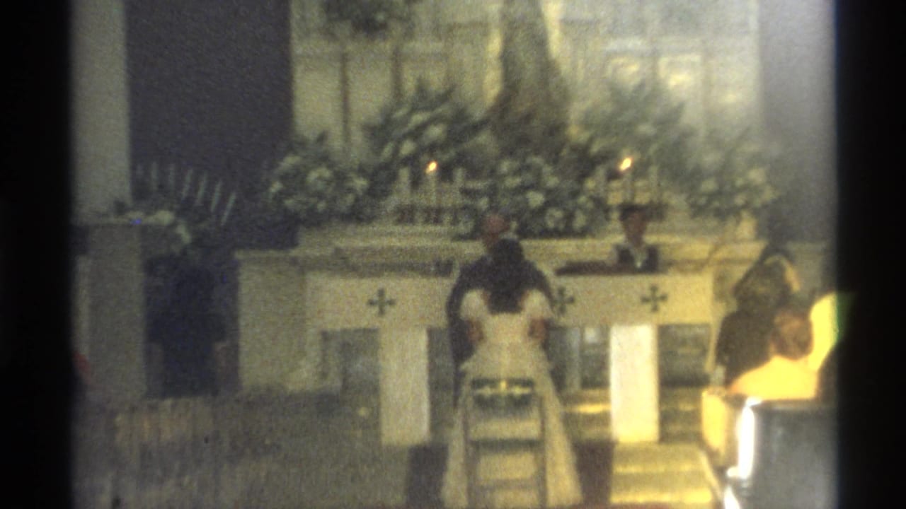 Bride and groom stand at a decorated church altar during a wedding service.