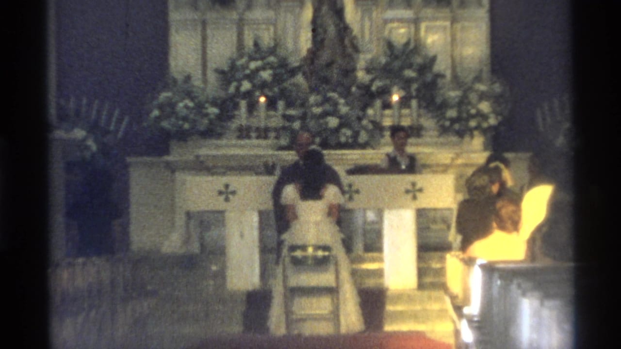 Bride and groom kneel at a church altar during a wedding ceremony.