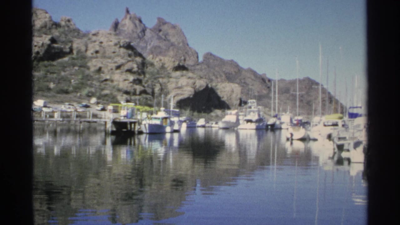 Marina boats and sailboat masts reflected in still water.