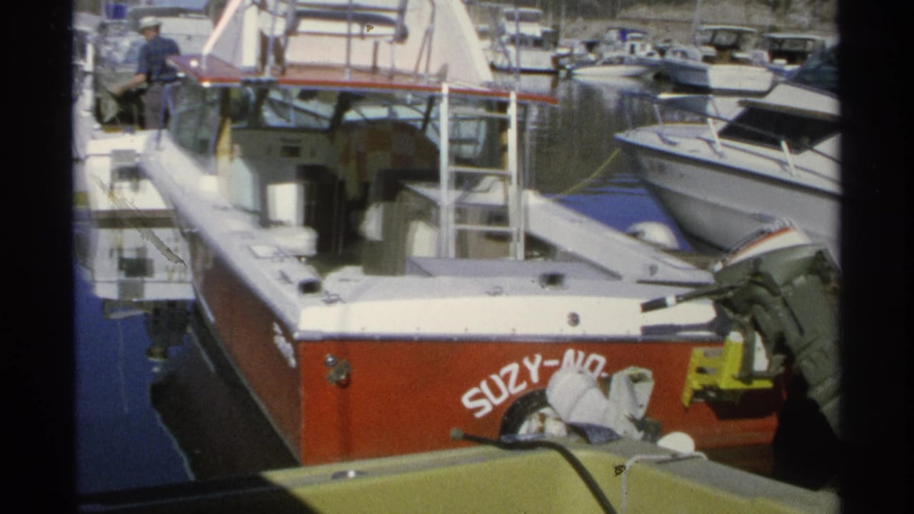 1975 Guaymas marina view of a red-and-white boat named SUZY-NO tied among nearby small boats.