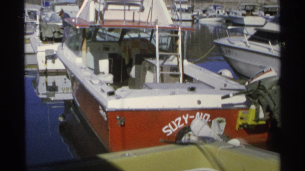 Close marina view of SUZY-NO with neighboring boats and dock hardware.