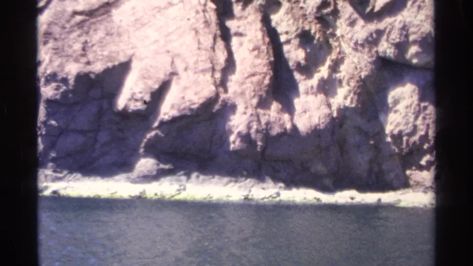 Sunlit rocky cliff and shoreline near Guaymas, Mexico, filmed from the water on 8mm in 1975.