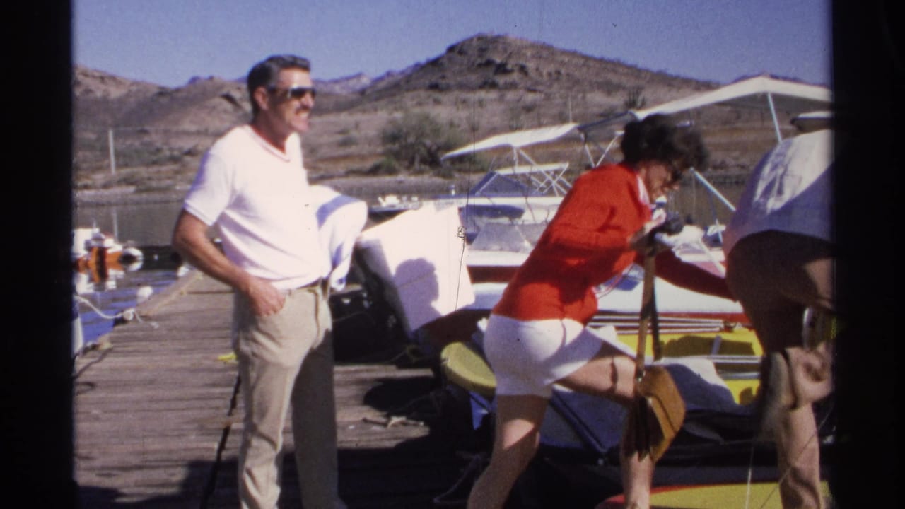 1975 Guaymas frame of adults beside a moored boat on a wooden dock, with one woman stepping near the boat and a man watching.