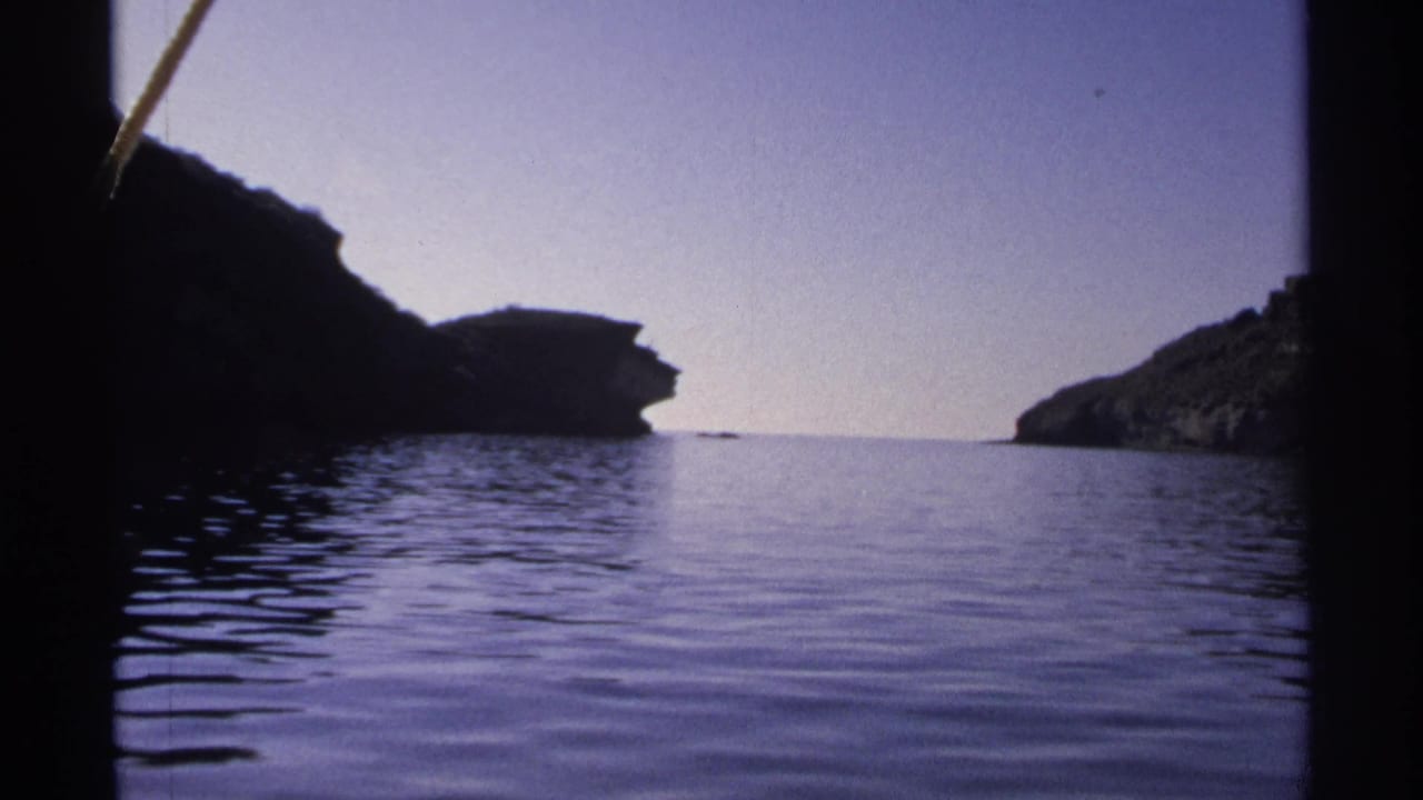 Rocky shoreline and calm water with dark cliffs framing the passage.