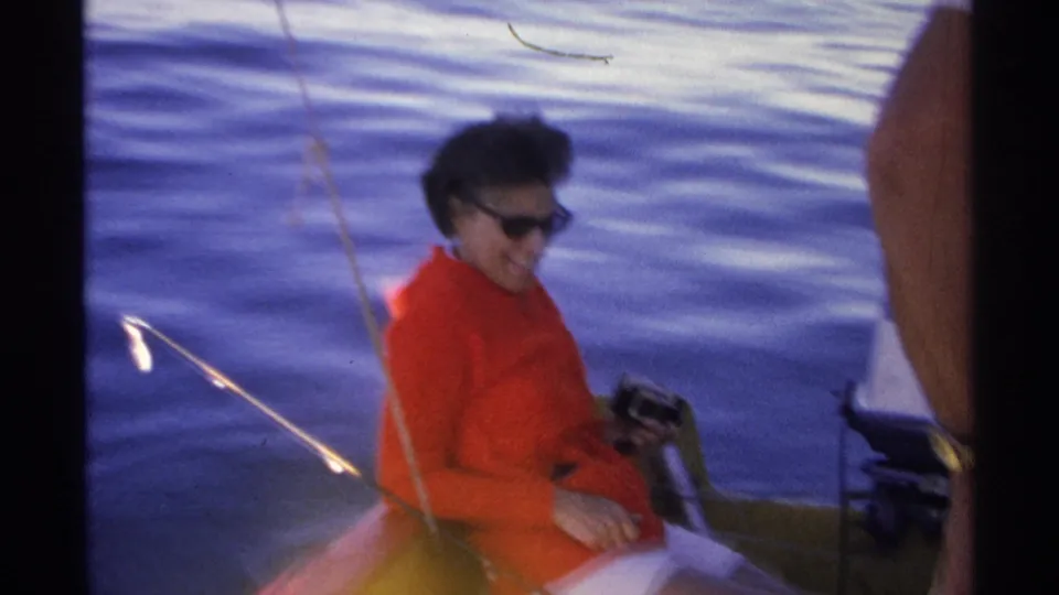 The Guaymas boat scene continues with the woman in red seated near fishing gear, partly blocked by a standing person and the dark contact-sheet divider.