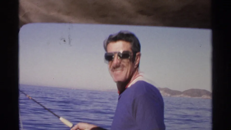 In Guaymas, Mexico, the man turns from fishing and smiles toward the 8mm camera on the boat.