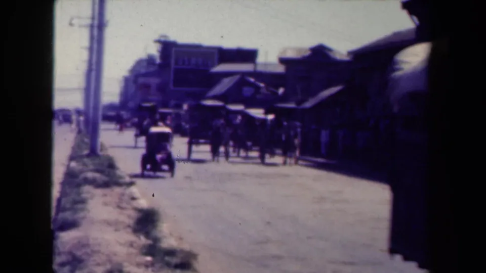 A wider Manila street view shows pedestrians, a small vehicle, shaded storefronts, and utility poles along a bright dusty road.