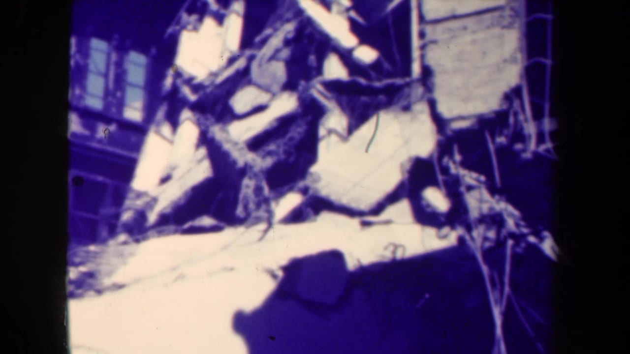 Close view of rubble and broken building materials beside a damaged structure.