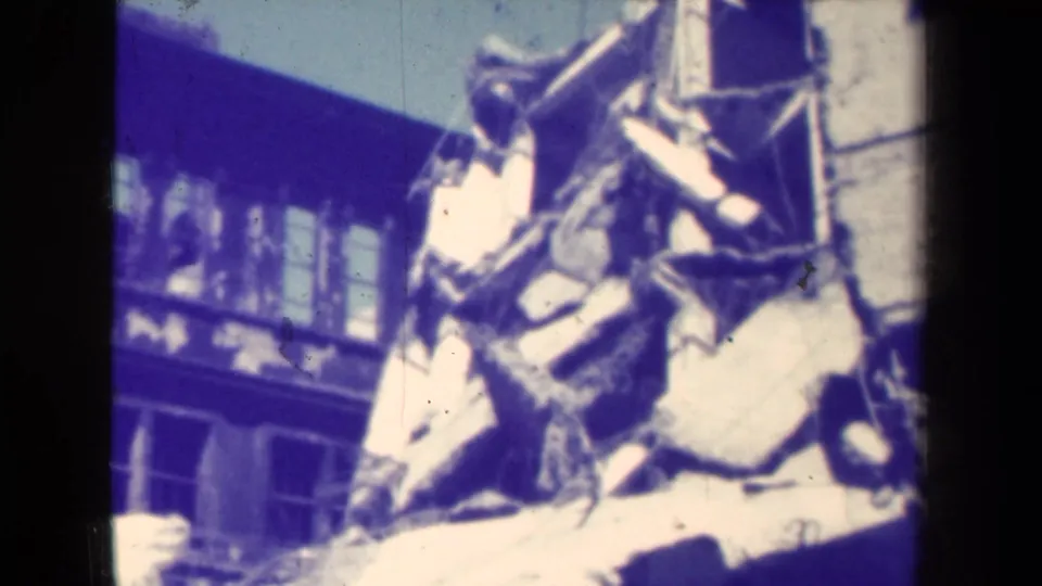 Final 1944 Manila frame showing broken concrete, scattered debris, and a damaged building surface in aged 8mm color.
