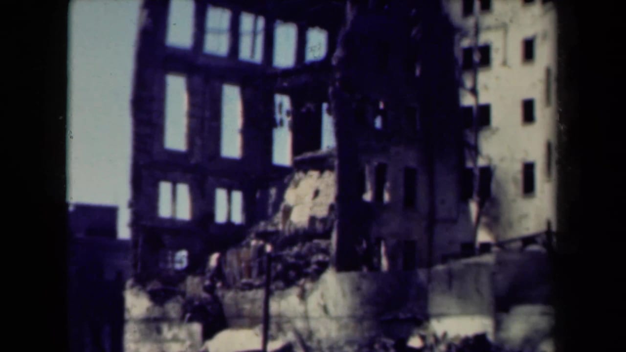 Damaged building facade with empty windows, rubble and dark film borders.