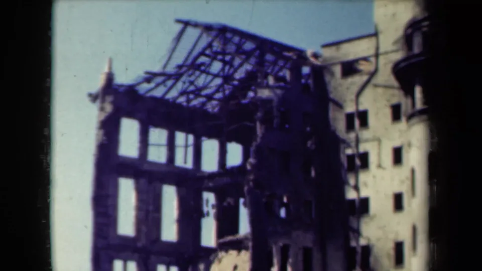 1944 Manila frame showing a damaged building crown, exposed roof grid, broken facade openings and nearby building wall.